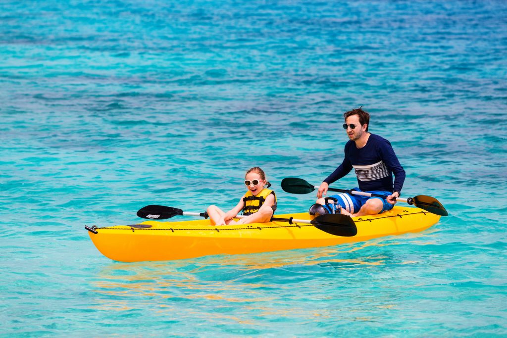 Family of father and daughter paddling on  kayaks b< Tripps Travel Network