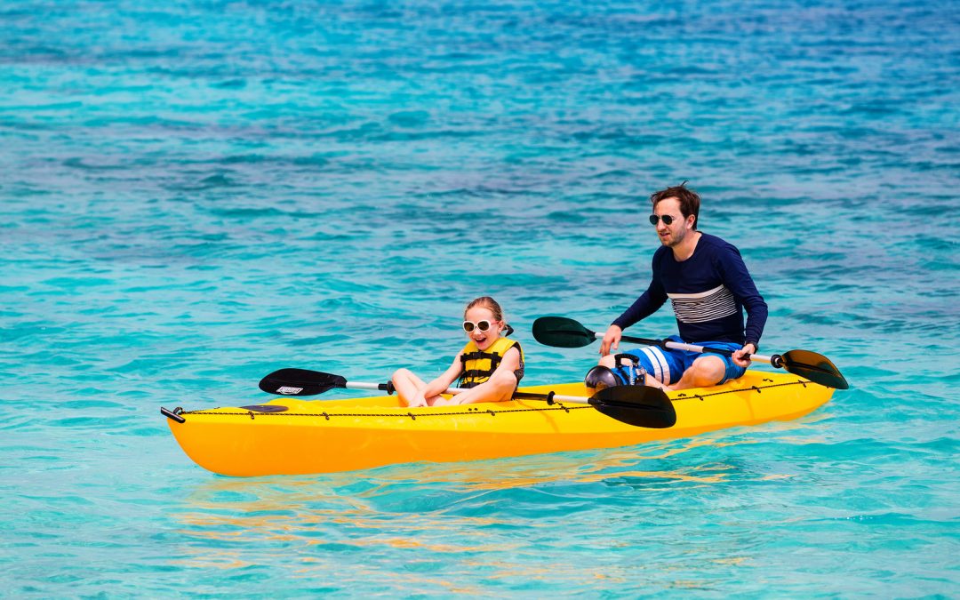 Family of father and daughter paddling on kayaks b< Tripps Travel Network